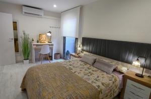 a bedroom with a large bed with a large headboard at APARTAMENTO LA UNIÓN in Castellón de la Plana