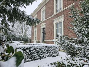 a brick building with snow covered bushes in front of it at Boutique Hotel Villa de Proosdij in Klimmen
