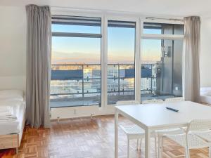- une chambre avec un lit, une table et une grande fenêtre dans l'établissement T&K Apartments - 2 and 3 Room Apartments - Heart of Solingen-Hofgarten, à Solingen