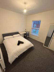 um quarto com uma cama branca e uma janela em Charming Liverpool Home em Liverpool