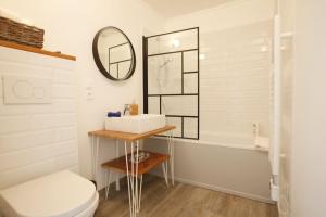 ein Badezimmer mit einem Waschbecken, einem WC und einer Badewanne in der Unterkunft Maison VIOGNIER in Condrieu