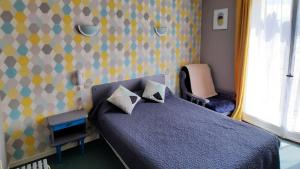 um quarto com uma cama azul com almofadas em Auberge Béarn Bigorre em Lamarque-Pontacq