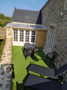 a patio with two chairs and a table and a grill at Gîte l'écurie 3 étoiles La HAGUE - MANCHE 2-5 pers avec SPA sur le GR 223 in Auderville