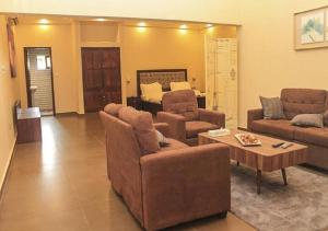 a living room with a couch and a coffee table at Hôtel Guest House Quatre Saisons in Cadjèhoun
