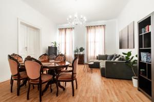 een woonkamer met een tafel en stoelen en een bank bij Internesto Brno Station in Brno