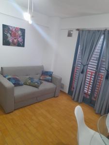 a living room with a couch and two windows at alquiler temporario en Córdoba Capital, excelente ubicación in Cordoba