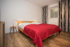 um quarto com uma cama com um cobertor vermelho em Appartement - Auf 'm Kampe 41 Winterberg-Neuastenberg em Winterberg