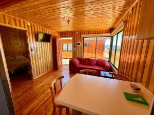 salon z czerwoną kanapą i stołem w obiekcie Cabañas Vista al Mar w mieście Valdivia