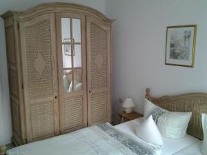 - une chambre avec une grande armoire en bois à côté d'un lit dans l'établissement Ferienwohnung Christa Hahn, à Birkenau
