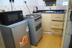 a kitchen with a stove and a tv on a refrigerator at SAGE Apartments-South B in Nairobi