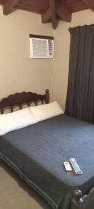 1 dormitorio con 1 cama con 2 mandos a distancia en QUIRUS DORMIS en Villa Carlos Paz