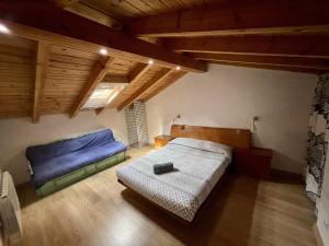 een slaapkamer met 2 bedden in een kamer met houten plafonds bij Chalet del Roble in Biescas