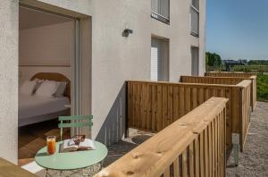 terraza de madera con cama y mesa en el balcón en La Clef des Châteaux, en Maslives