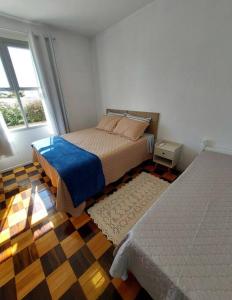 1 dormitorio con 2 camas y ventana en Casa de praia em Florianópolis, en Florianópolis