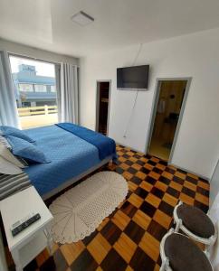 1 dormitorio con 1 cama y suelo a cuadros en Casa de praia em Florianópolis, en Florianópolis