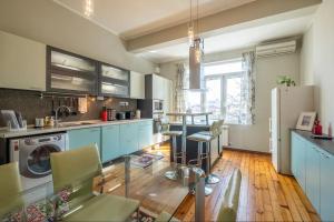 a kitchen with blue cabinets and a wooden floor at Charming 2BDR Apartment in Historic Center With Parking in Sofia