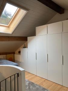 a bedroom with white cabinets and a skylight at "La Petite Rochette" in Estavayer-le-Lac