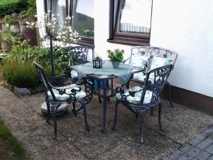 einen Tisch und zwei Stühle sowie einen Tisch mit einer Pflanze in der Unterkunft Ferienwohnung Christa Hahn in Birkenau