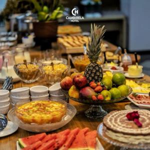 a table topped with lots of different types of food at Cambirela Hotel in Florianópolis