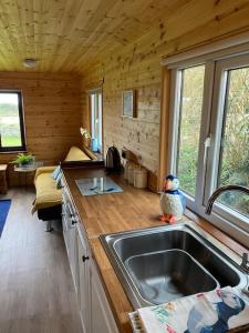 a kitchen with a sink in a log cabin at Idyllic Cornish Retreat At Puffin Lodge in Helston