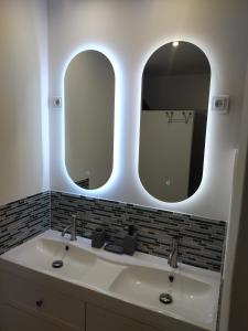 baño con lavabo y 2 espejos en Gîte l'écurie 3 étoiles La HAGUE - MANCHE 2-5 pers avec SPA sur le GR 223 en Auderville