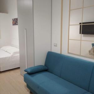 un soggiorno con divano blu e letto di Bell'House Milazzo a Milazzo