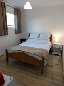 een slaapkamer met een groot bed met witte lakens en een raam bij Lymore Guest house in Palamarza