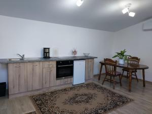 a kitchen with wooden cabinets and a table with chairs at Lymore Guest house in Palamarca