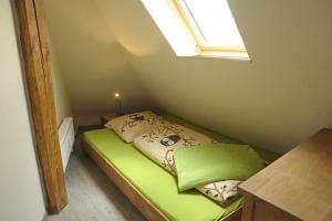 Dormitorio pequeño con cama verde y ventana en Ferienwohnung Müller-Wulf, en Schleswig