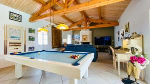 una sala de estar con una mesa de billar. en Magnifique villa avec piscine et billard en Saint-Martin-de-Ré