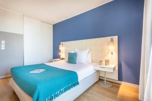 - une chambre avec un grand lit et un mur bleu dans l'établissement Zenitude Hôtel Résidences Marseille Saint-Charles, à Marseille