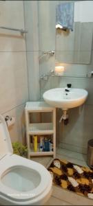 a bathroom with a white toilet and a sink at White villa resort dodangoda in Kalutara
