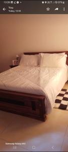 a bedroom with a bed with white sheets and pillows at White villa resort dodangoda in Kalutara