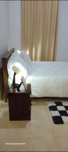 a bedroom with a bed and a lamp on a table at White villa resort dodangoda in Kalutara