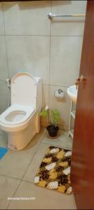 a bathroom with a toilet and a cow rug at White villa resort dodangoda in Kalutara