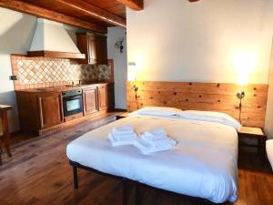 een slaapkamer met een groot wit bed en 2 handdoeken bij Residence Du Commerce in Oulx