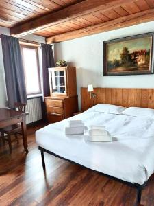 a bedroom with a large white bed and a piano at Residence Du Commerce in Oulx