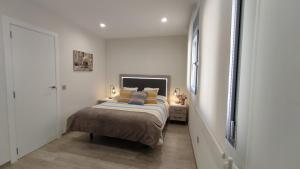 a bedroom with a bed in a white room at Apartamento la Unión II , calidad y comodidad in Castellón de la Plana