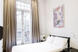 1 dormitorio con cama blanca y ventana en The One Bramham en Londres