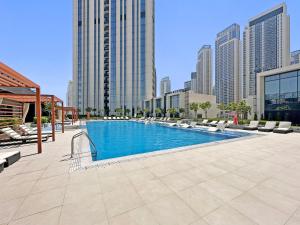 a swimming pool in a city with tall buildings at Mesmerizing 2BDR in Creek Harbour HG1-1907 in Dubai