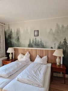 a bedroom with two beds with trees on the wall at Harz Hotel Waldhaus in Goslar