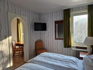 a bedroom with a bed and a window and a table at Harz Hotel Waldhaus in Goslar