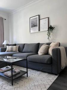 a living room with a blue couch and a table at Guest Homes - Driffield Apartment in Great Driffield