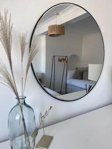 a mirror on a wall with a vase and a bedroom at Guest Homes - Driffield Apartment in Great Driffield