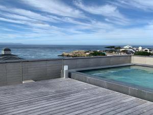 uma piscina em cima de uma casa com o oceano em Hermanus Waterfront Apartment em Hermanus
