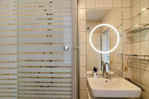 a bathroom with a sink and a shower with a mirror at Ferienwohnung Boje 20 in Schillig +14 photos