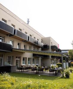 um grande edifício com mesas e cadeiras num quintal em Hotel Max 70 em Salzburgo