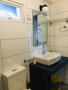 a bathroom with a sink and a toilet and a mirror at Aquaa Leaf Residences in Nuwara Eliya