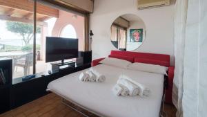 ein Schlafzimmer mit einem weißen Bett mit zwei Schuhpaaren in der Unterkunft Welcomely - Verde Mare in Marinella