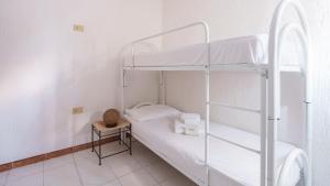 - une chambre avec 2 lits superposés et une table dans l'établissement Welcomely - Acqua e Tramonto, à Olbia